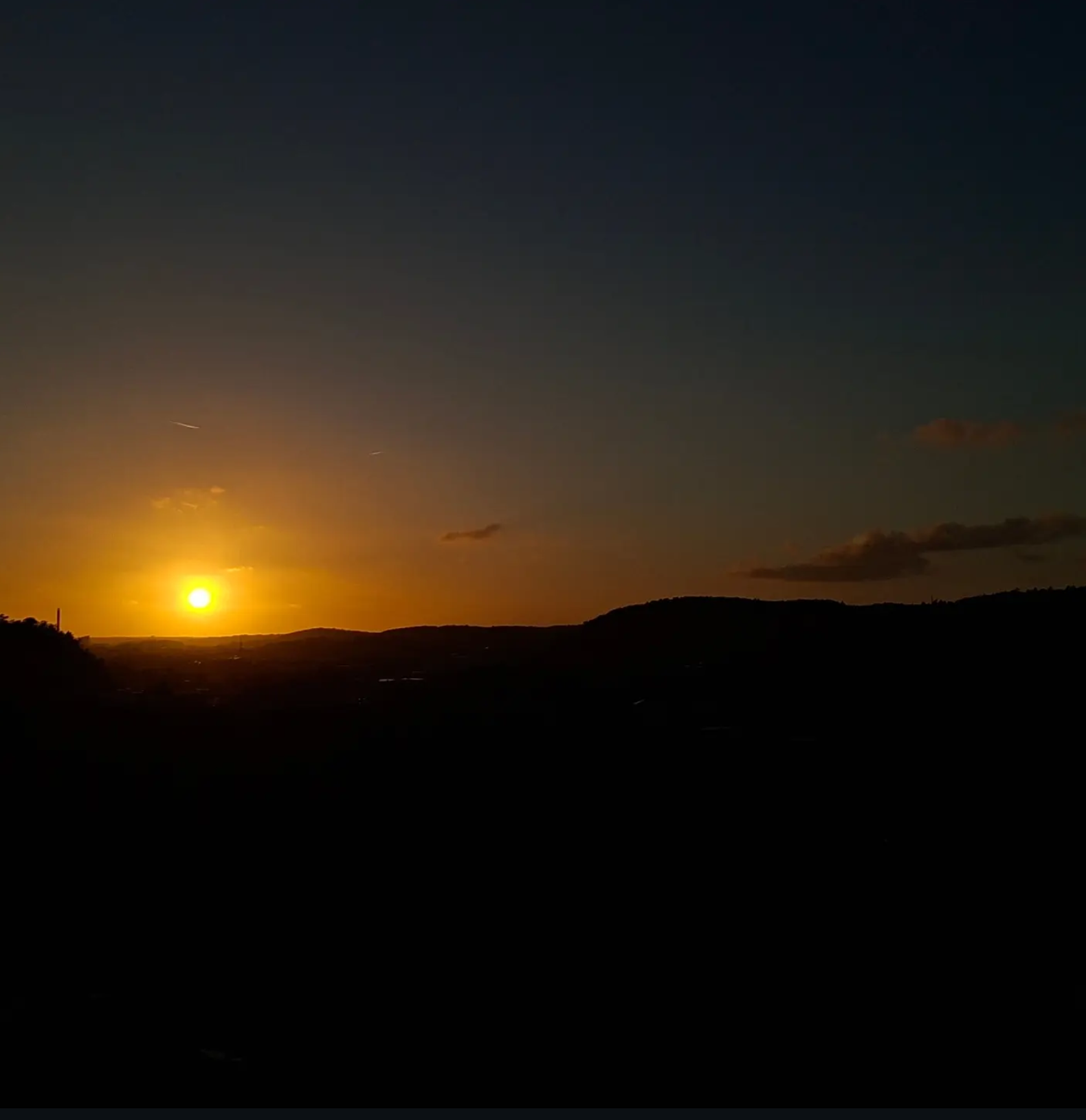 Sunset over dark hills, photographed from an eleventh-floor balcony in Partille